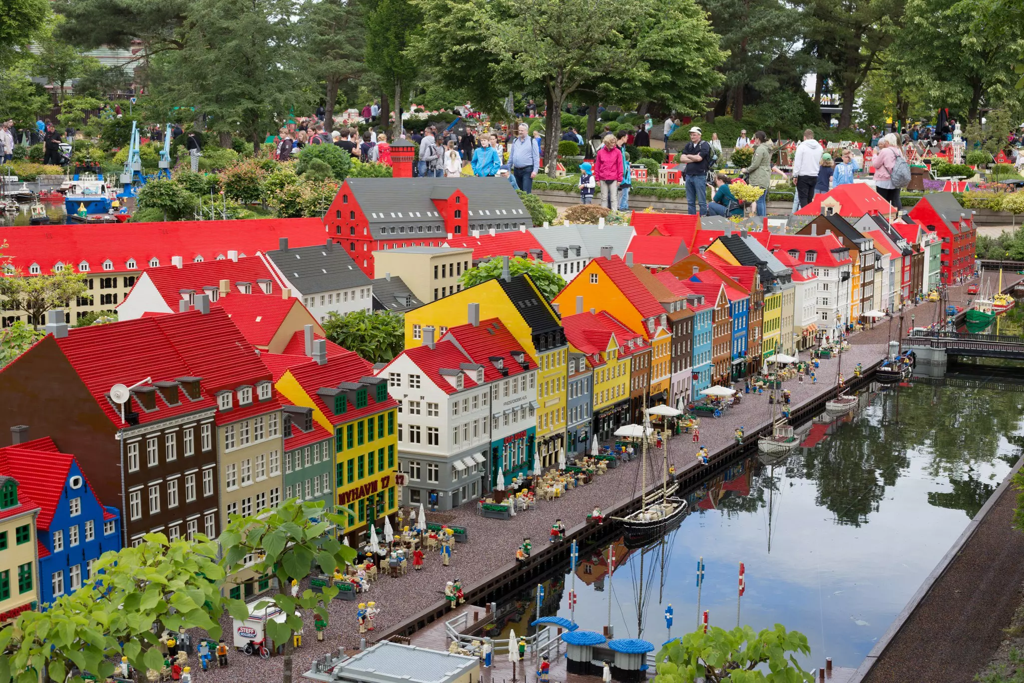 People walk past a miniature diorama of a city street constructed from Lego bricks.