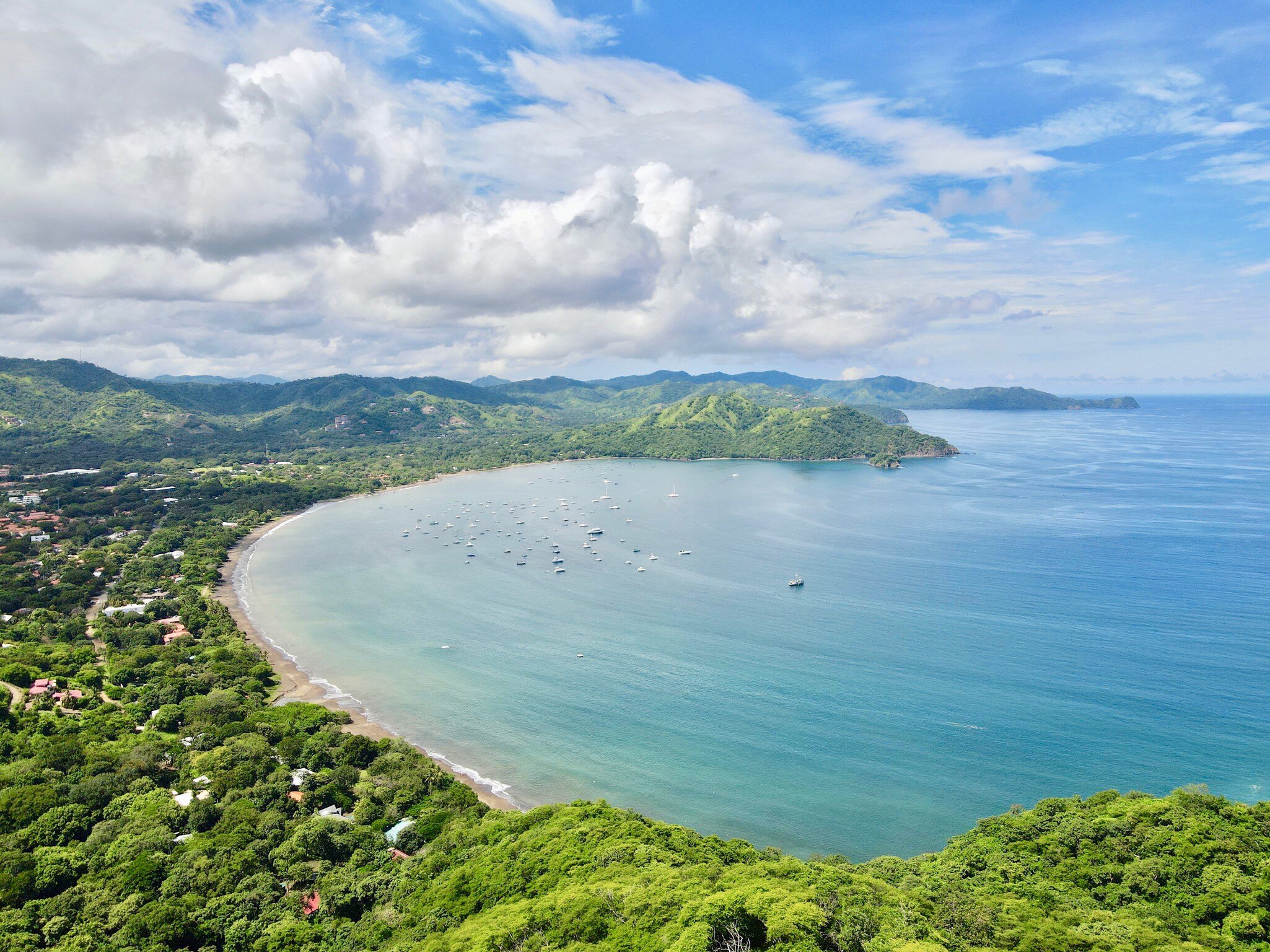 Aerial shot of Playas Del Coco Bay in Costa Rica, a tropical Pacific beach bay with boats in the water.