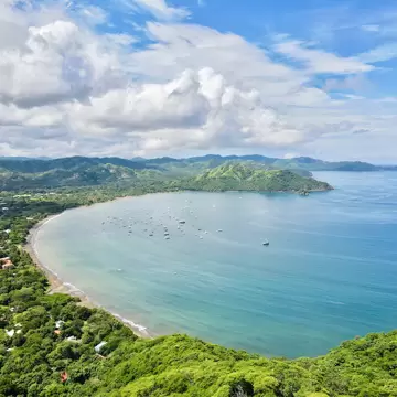 Aerial shot of Playas Del Coco Bay in Costa Rica, a tropical Pacific beach bay with boats in the water.
