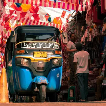 An autorickshaw passes under Indonesian flags in a market in Jakarta, Indonesia. 