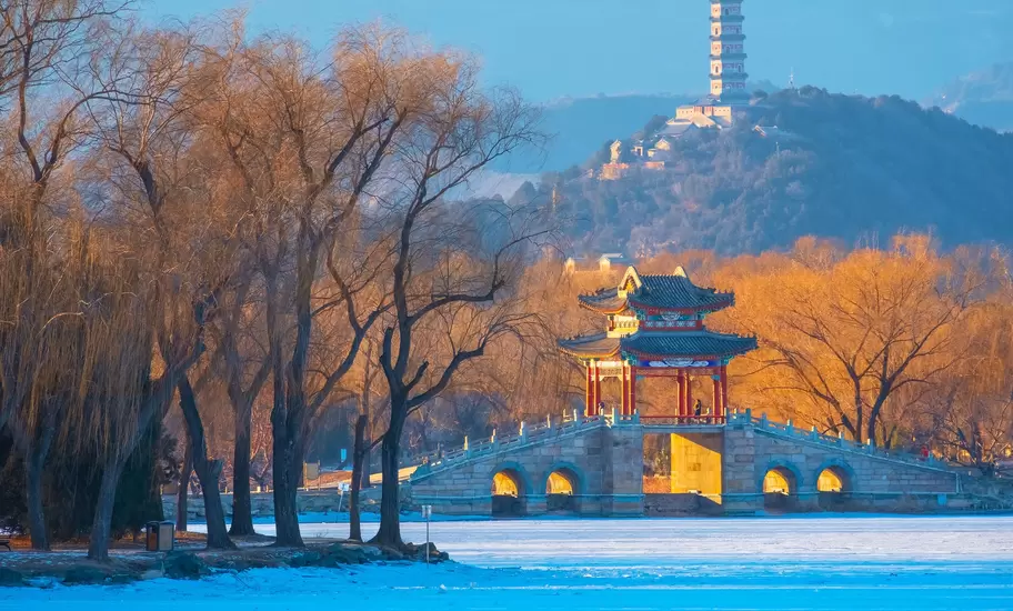 Autumnal view of a boat on a lake, with a temple in the background, in Hangzhou, China.