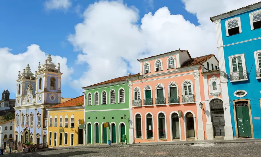 Pastel colonial houses and the blue baroque Rosário dos Pretos church on the Pelourinho's cobbled square, Salvador