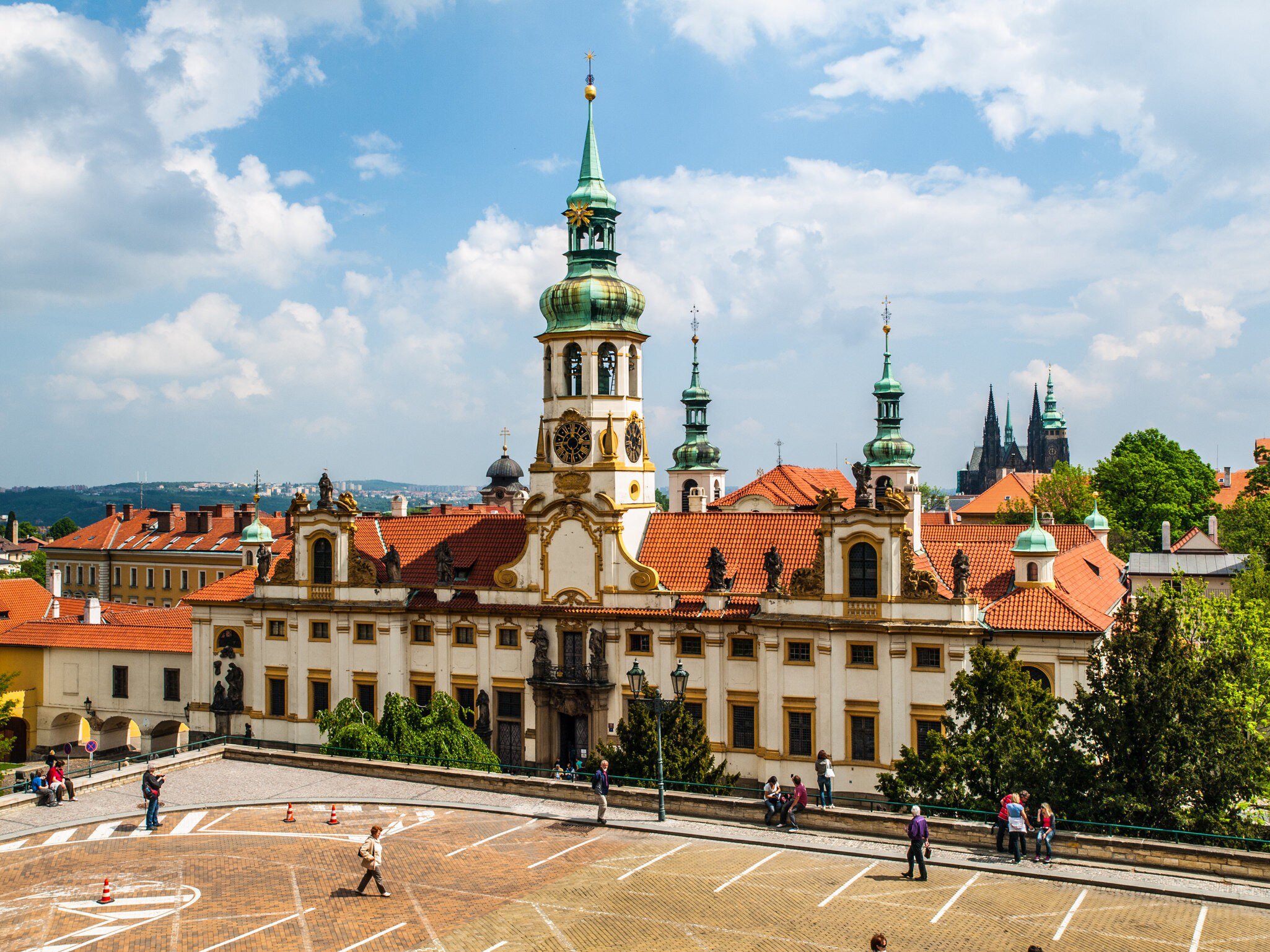 Exterior of Loreto/Loreta in Prague, Czech Republic.  Pedestrians walking and blue sky.