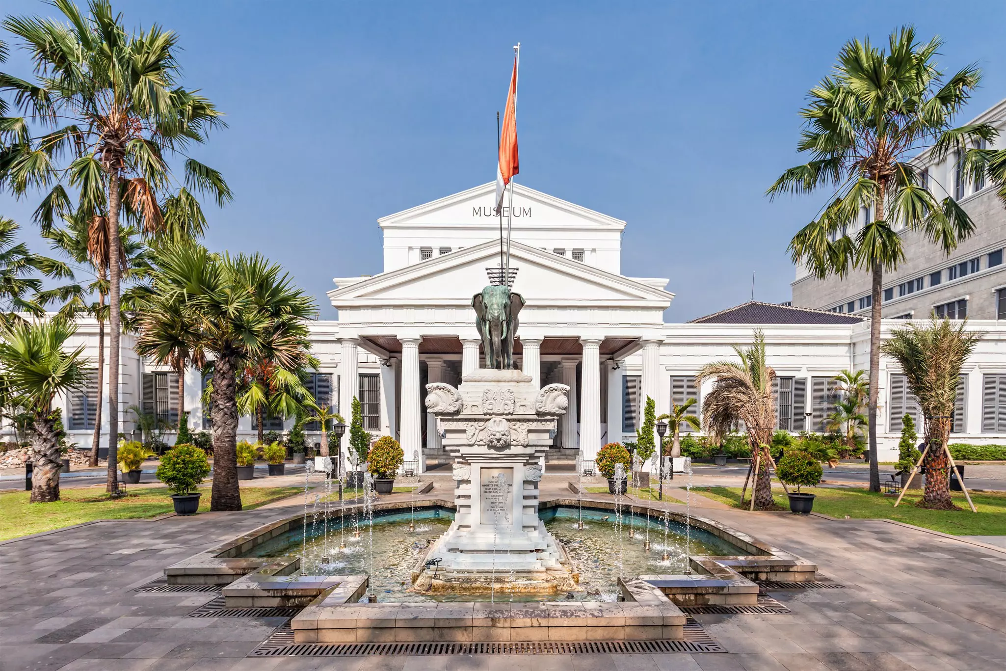 Statues and palms in front of the National Museum of Indonesia.