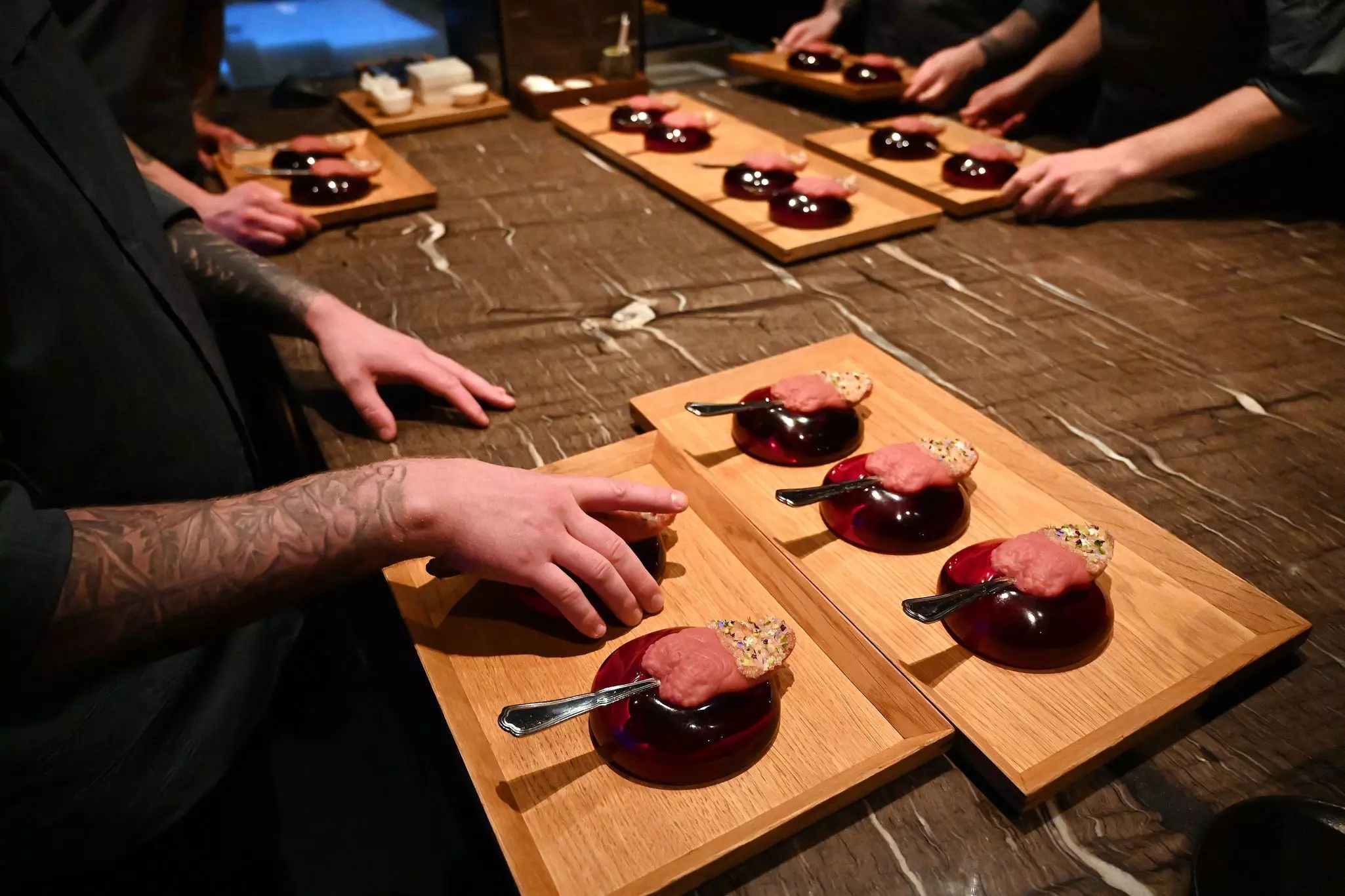 Servers and chefs at a restaurant prepare deluxe dishes for patrons.