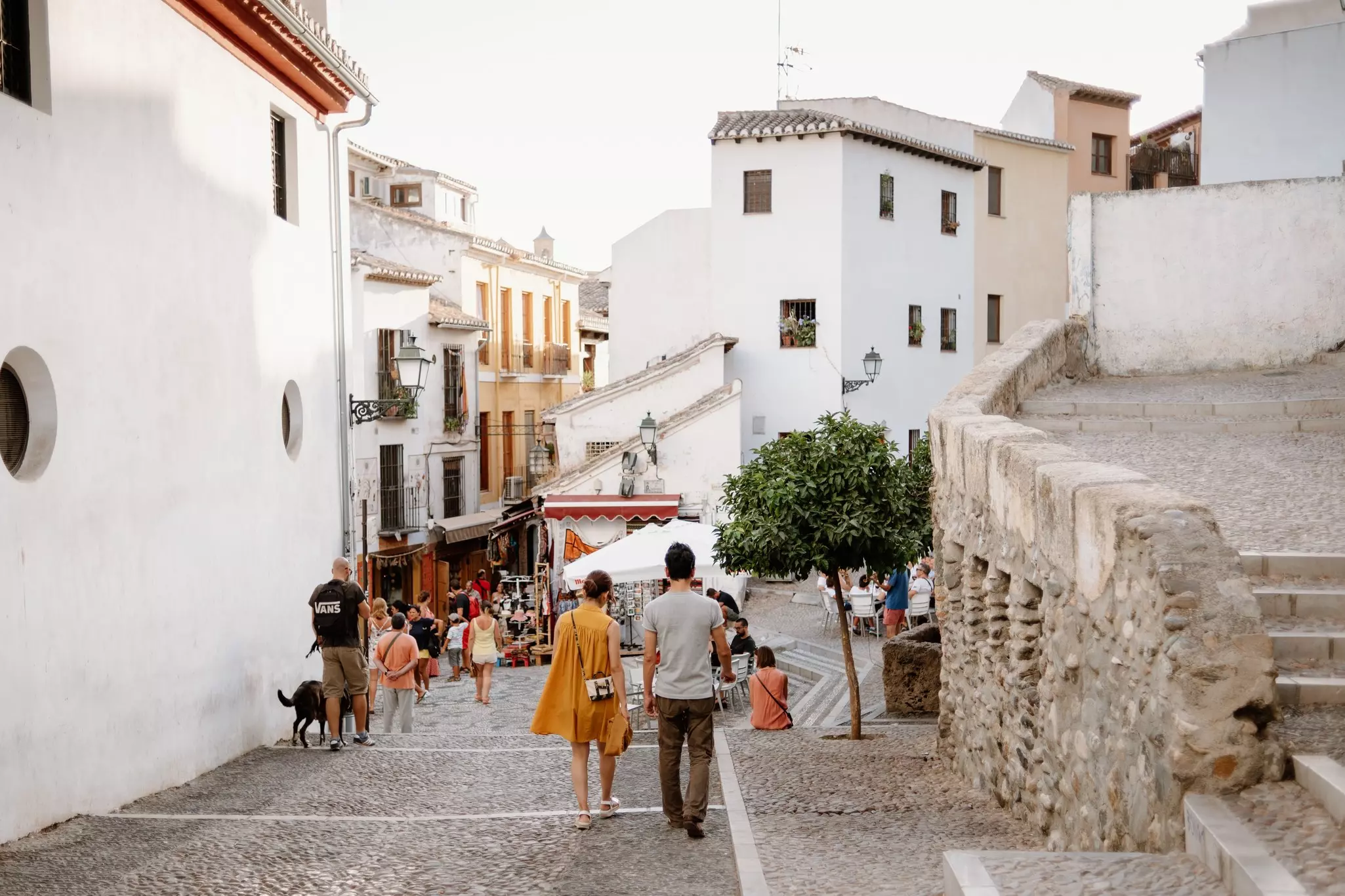 People wander through the white-building-lined streets of the old quarter of Albaicin, Granada.