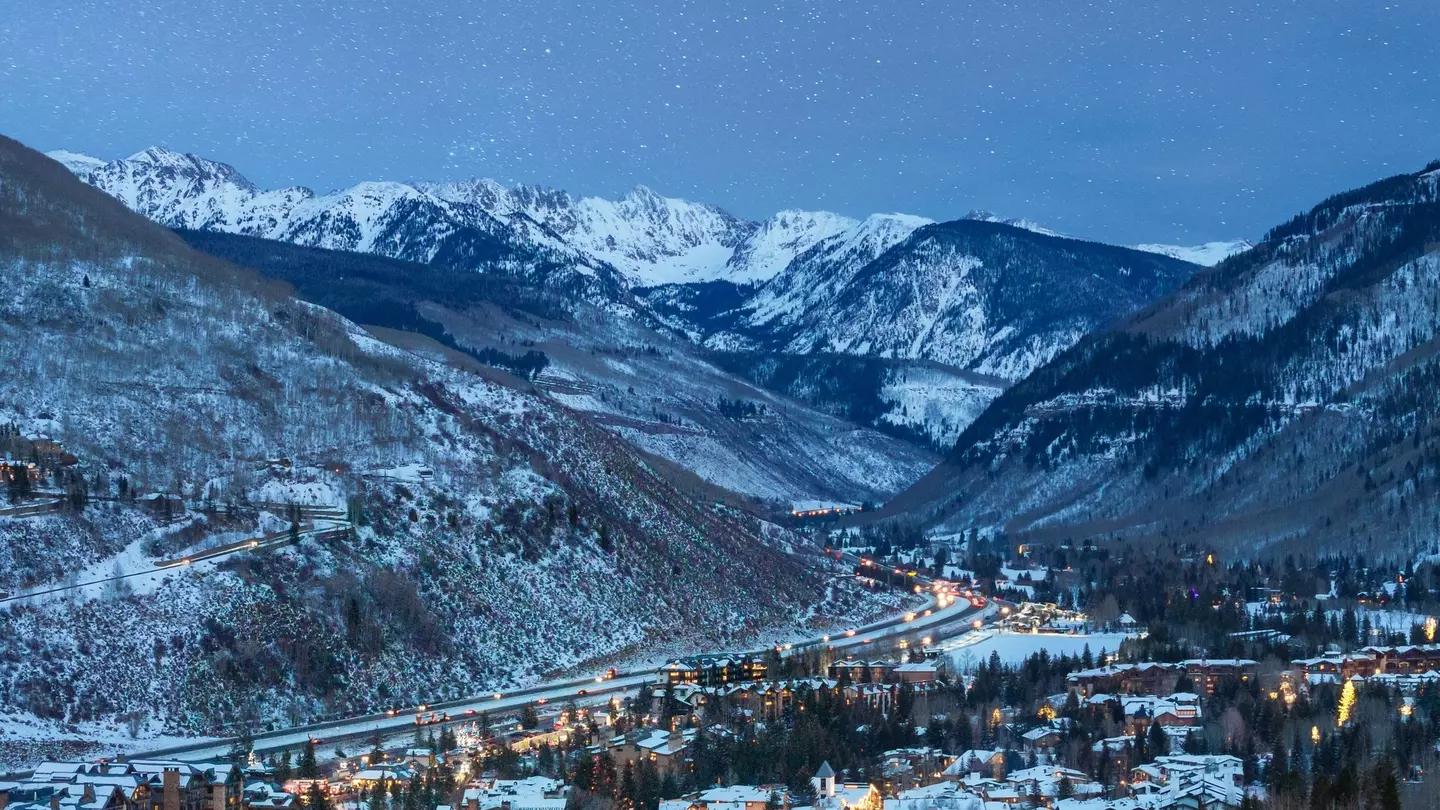 A starlit evening with a view of snow-topped homes and mountains in Vail, Colorado.