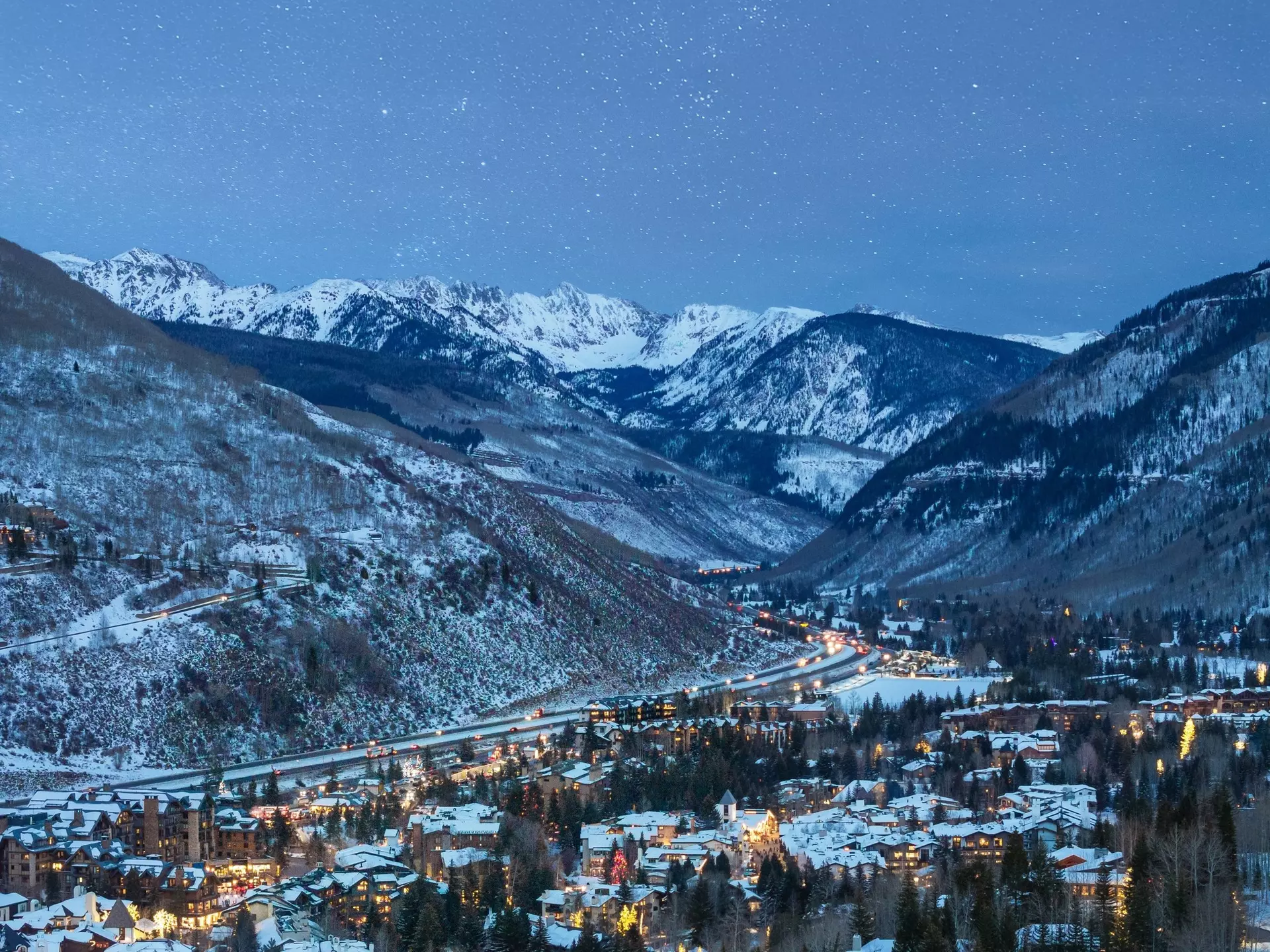 A starlit evening with a view of snow-topped homes and mountains in Vail, Colorado.