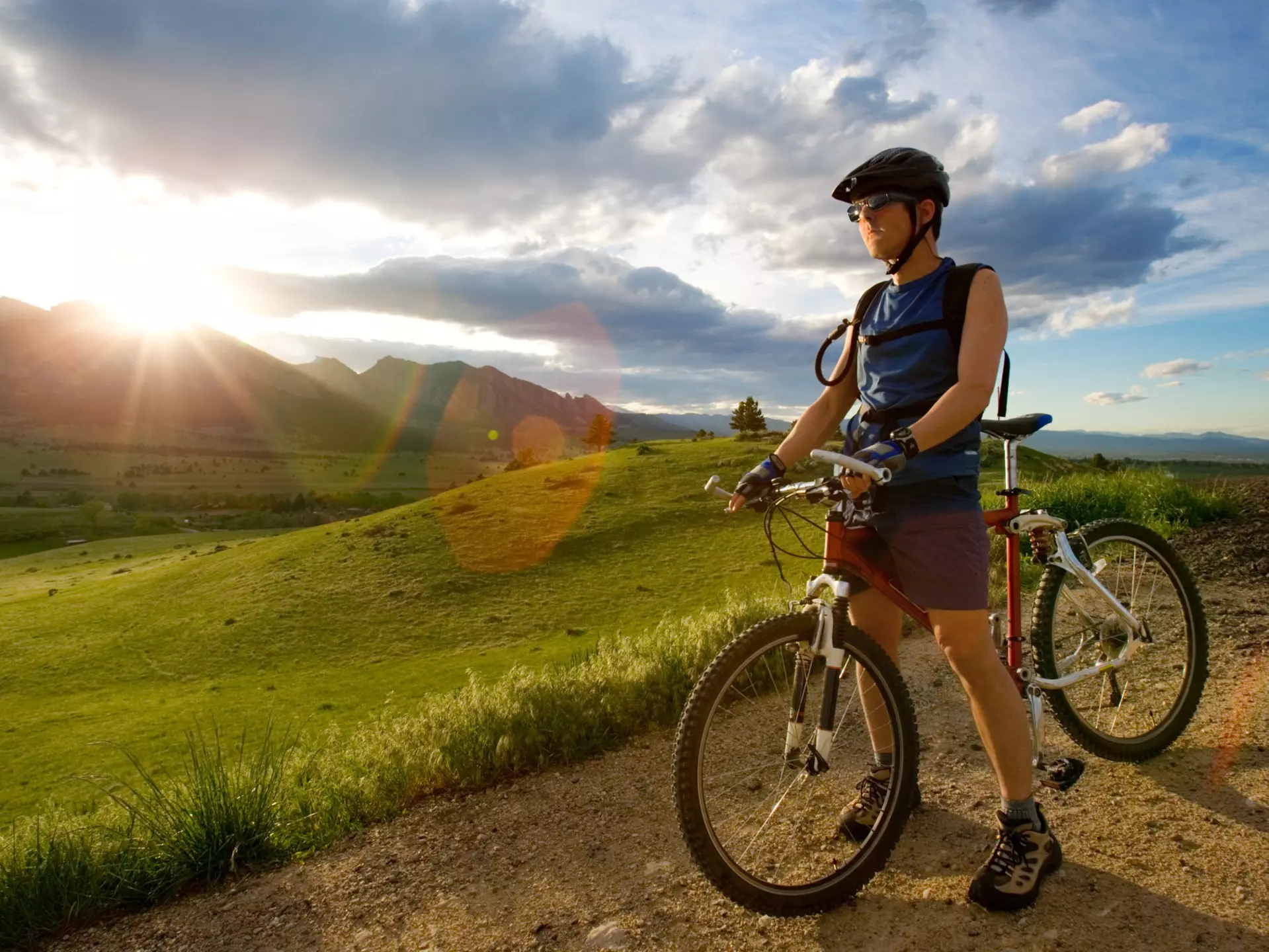 A man standing in a dirt road with a bike