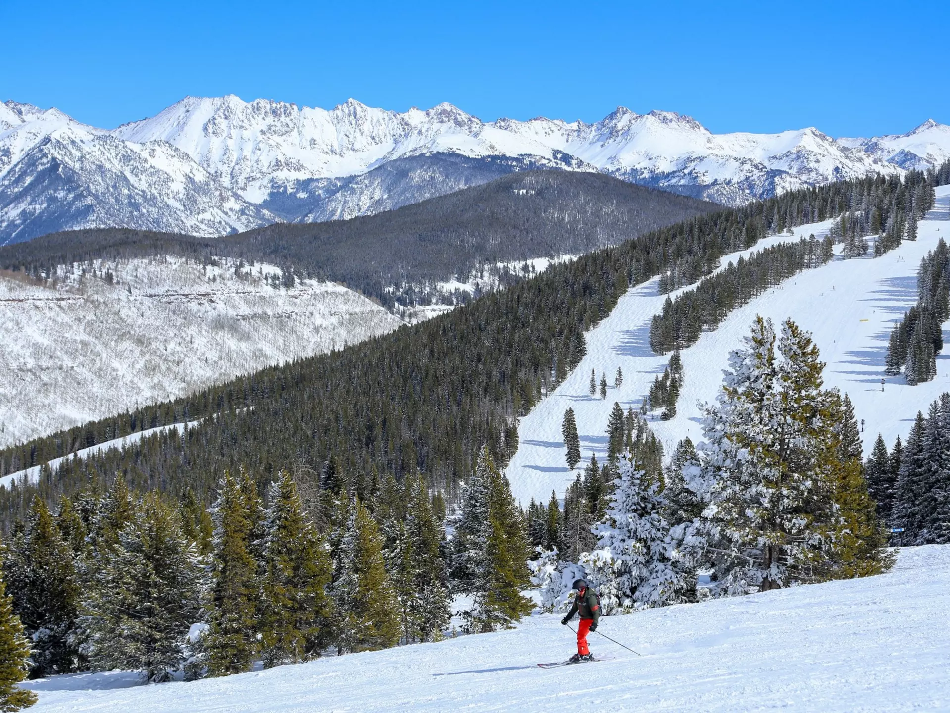 Male skier at Vail Ski resort in the Colorado Rocky Mountains on a blue sky day