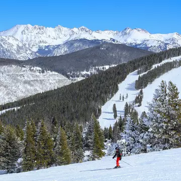 Male skier at Vail Ski resort in the Colorado Rocky Mountains on a blue sky day