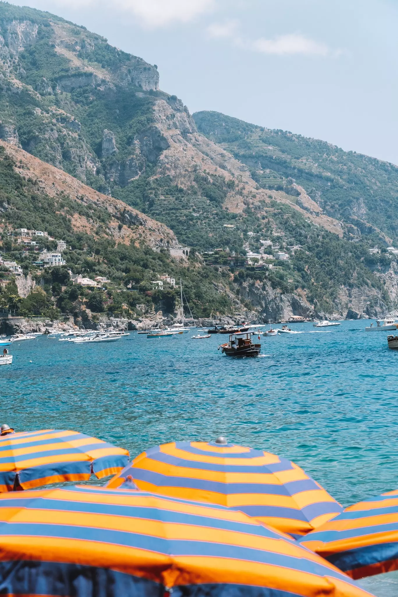Strand mit Positan mit klasi gestreiften Sonnenschirmen im Vordergrund, License Type: media, Download Time: 2026-05-21T16:58:09.000Z, User: lonelyplanetmedia, Editorial: false, purchase_order: 65050 - Digital Destinations and Articles, job: Comp Ingestion, client: Global Publishing WIP, other: Pia Peterson