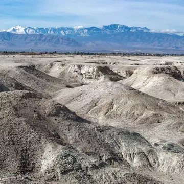 USA, Nevada, Clark County, Tule Fossil Beds National Monument: White gypsum hills at the urban fringe along the Las Vegas Wash with Mt. Charleston in the distance.; Shutterstock ID 1583690590; your: Bridget Brown; gl: 65050; netsuite: Online Edito...