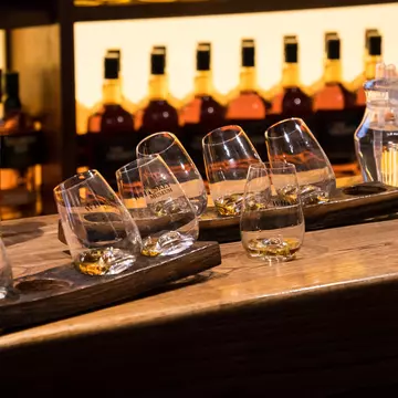 Empty whiskey glasses on a bar counter at the Irish Whiskey Museum. The Dublin Whiskey Museum explains history of Irish Whiskey and invites to taste a few of them.