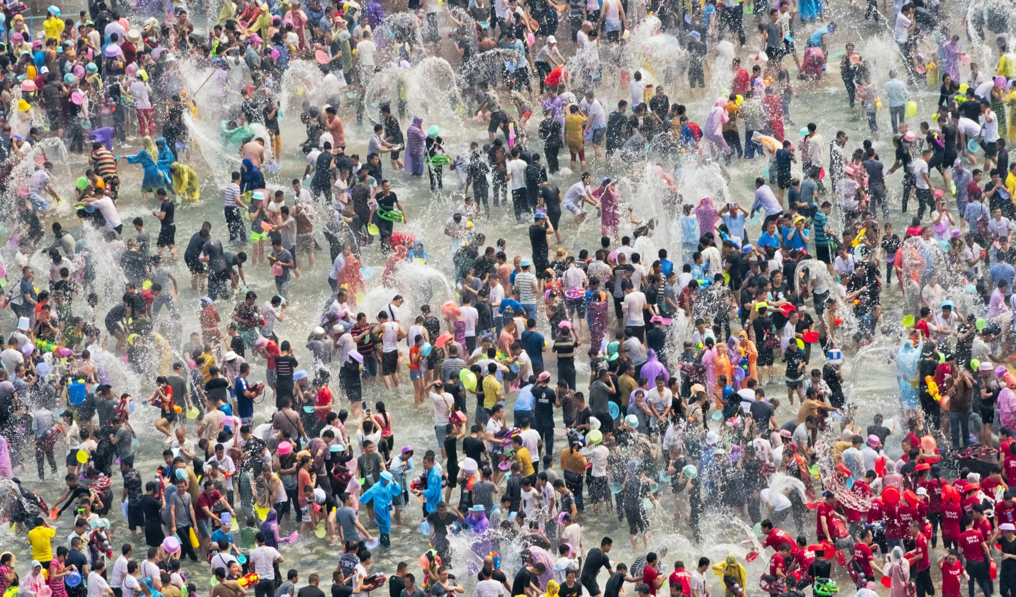 A huge crowd of people dousing each other in water as part of a massive water festival.