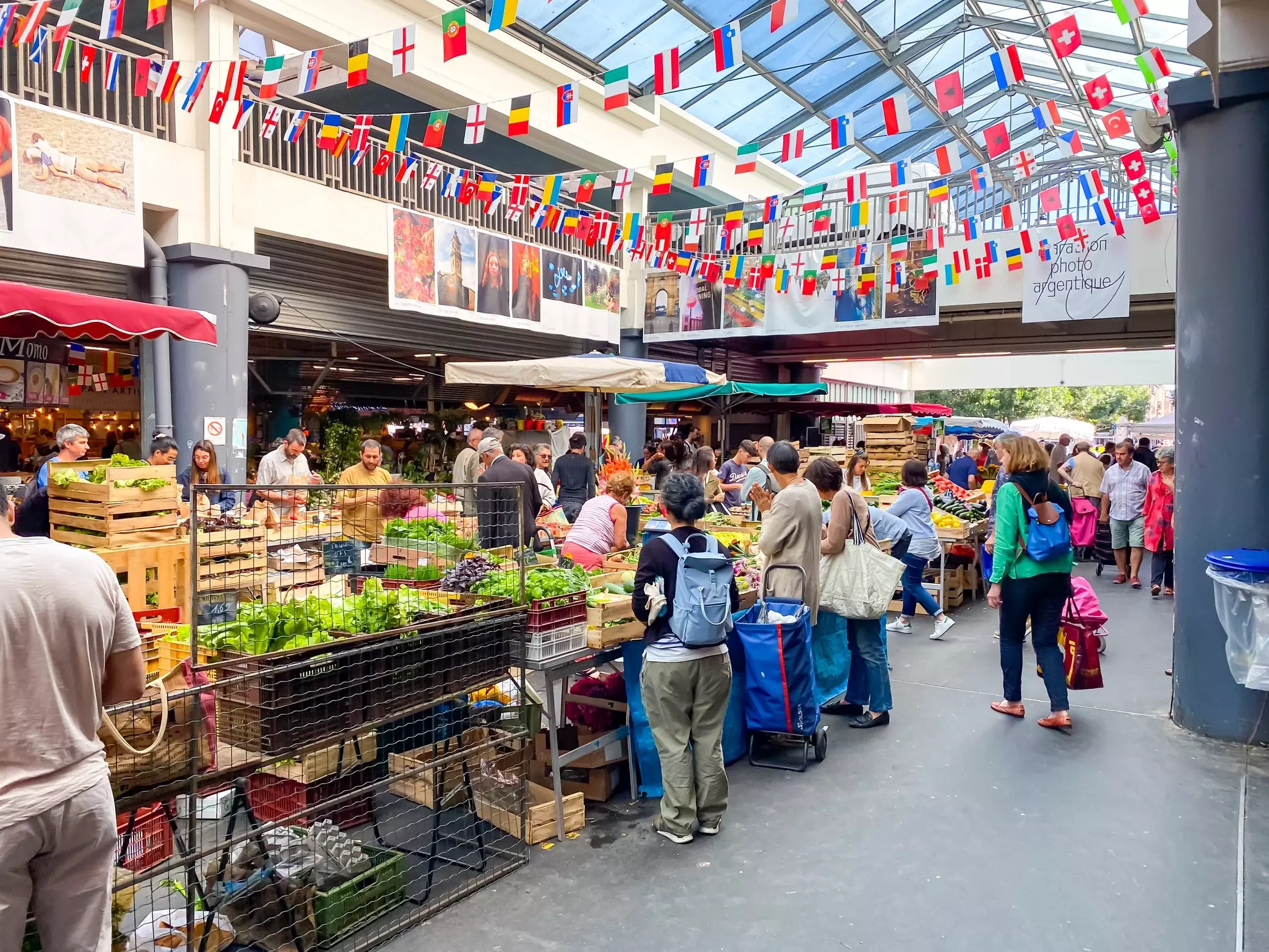 People browsing and buying in a covered fresh-food market.