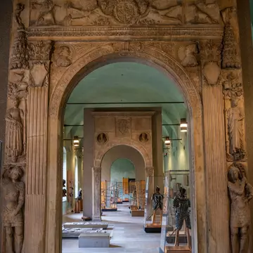 The hall with a funerary sarcophagus and other funerary excavations, statues and sculptures at the exhibit in the museum of the Sforzesco Castle.