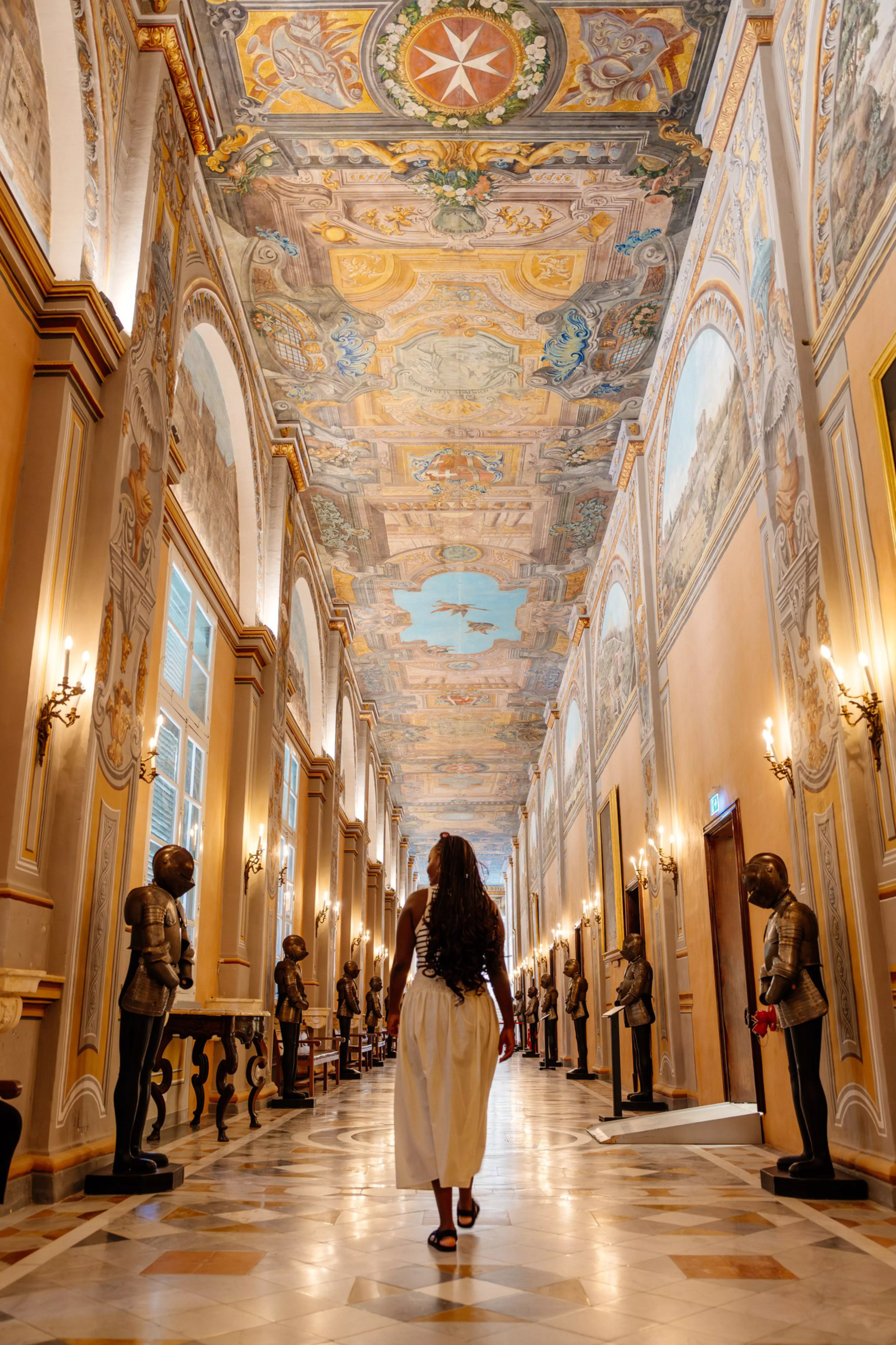 Jacklynn walking through the ornate hallway of the Grandmaster's Palace in Valletta.