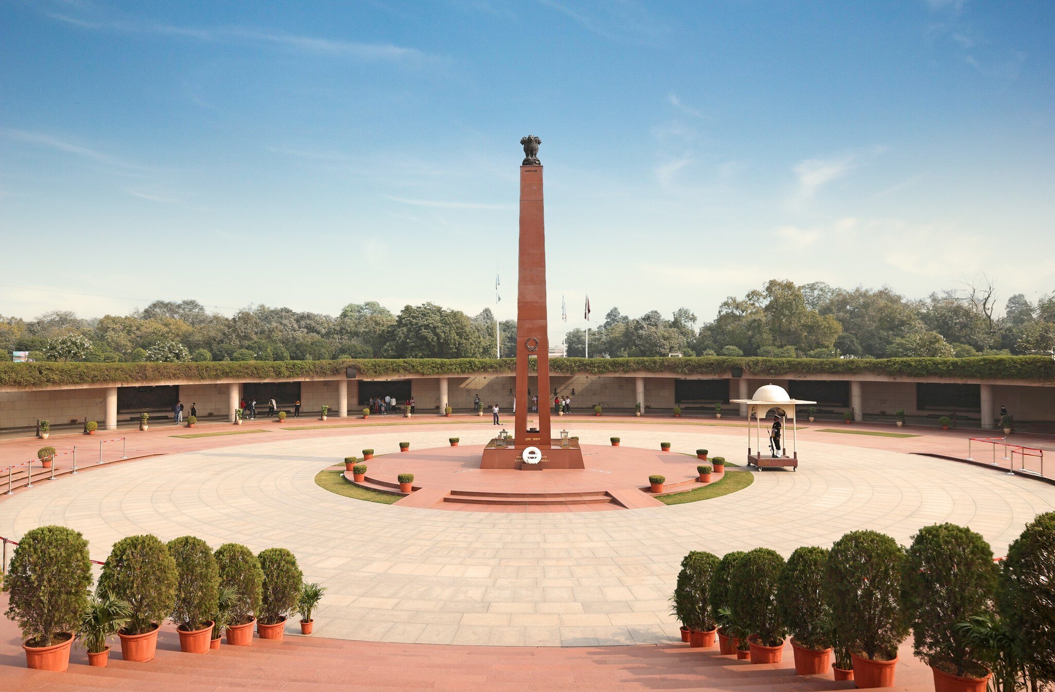 Wide high angle view of the central obelisk monument and circular courtyard layout at the National War Memorial complex in New Delhi, India.