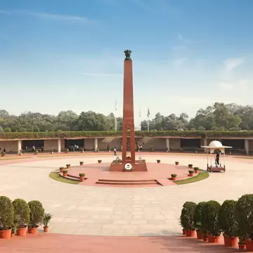 Wide high angle view of the central obelisk monument and circular courtyard layout at the National War Memorial complex in New Delhi, India.