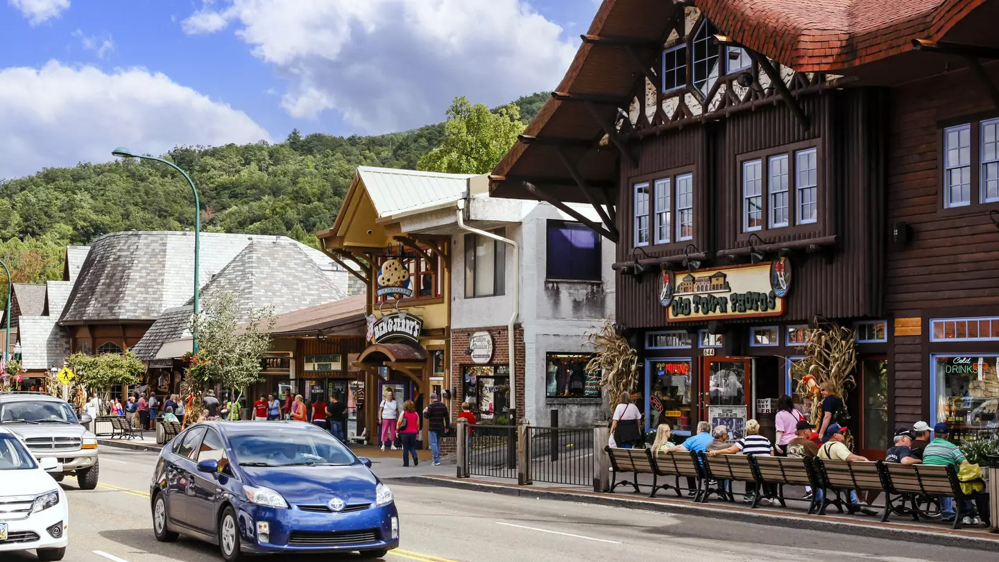 People walking around Main Street in downtown Gatlinburg Tennessee, USA. The street has an old-world feel to it, with heritage buildings, where people eat and drink outside.