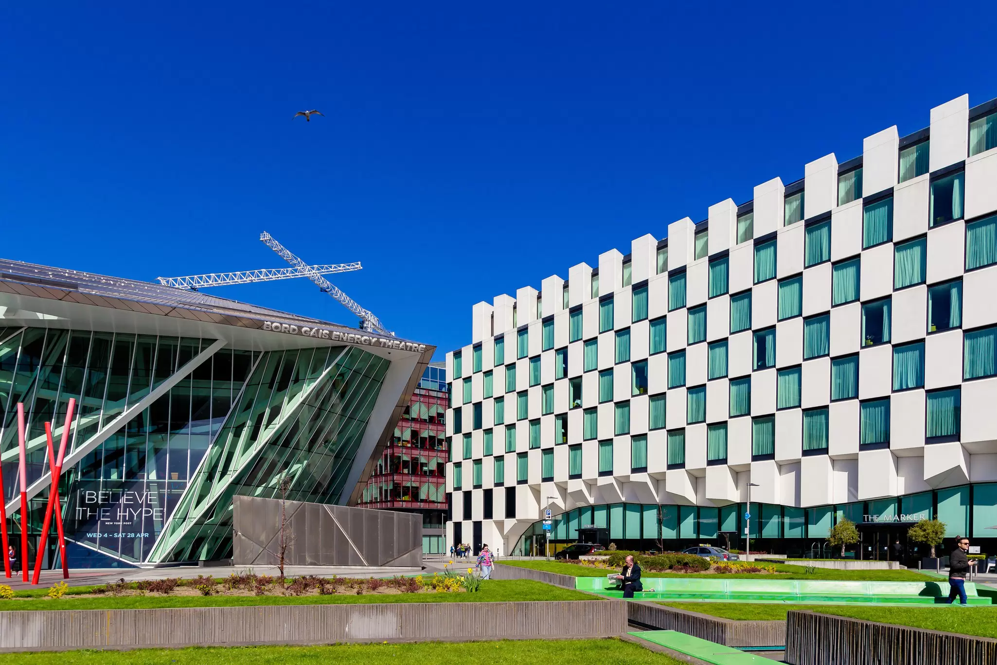 People enjoying the sun in the green spaces outside Anantara The Marker Hotel in Dublin. 