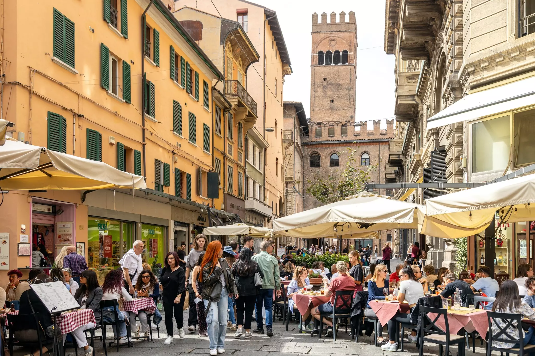 Busy street with people enjoying outdoor dining