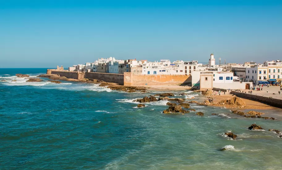 white buildings with a tan wall near the ocean