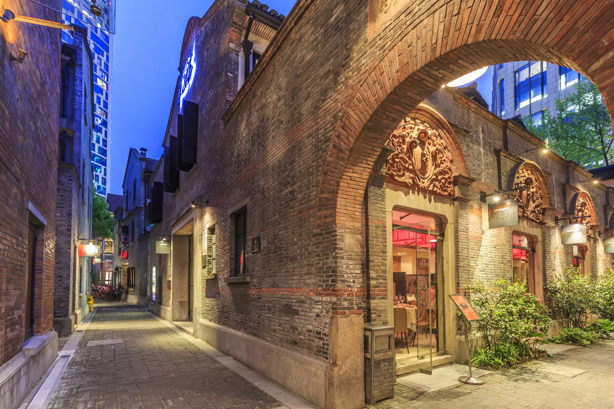 A shikumen gateway leads to a courtyard with restaurants in Xintiandi, Shanghai, China.