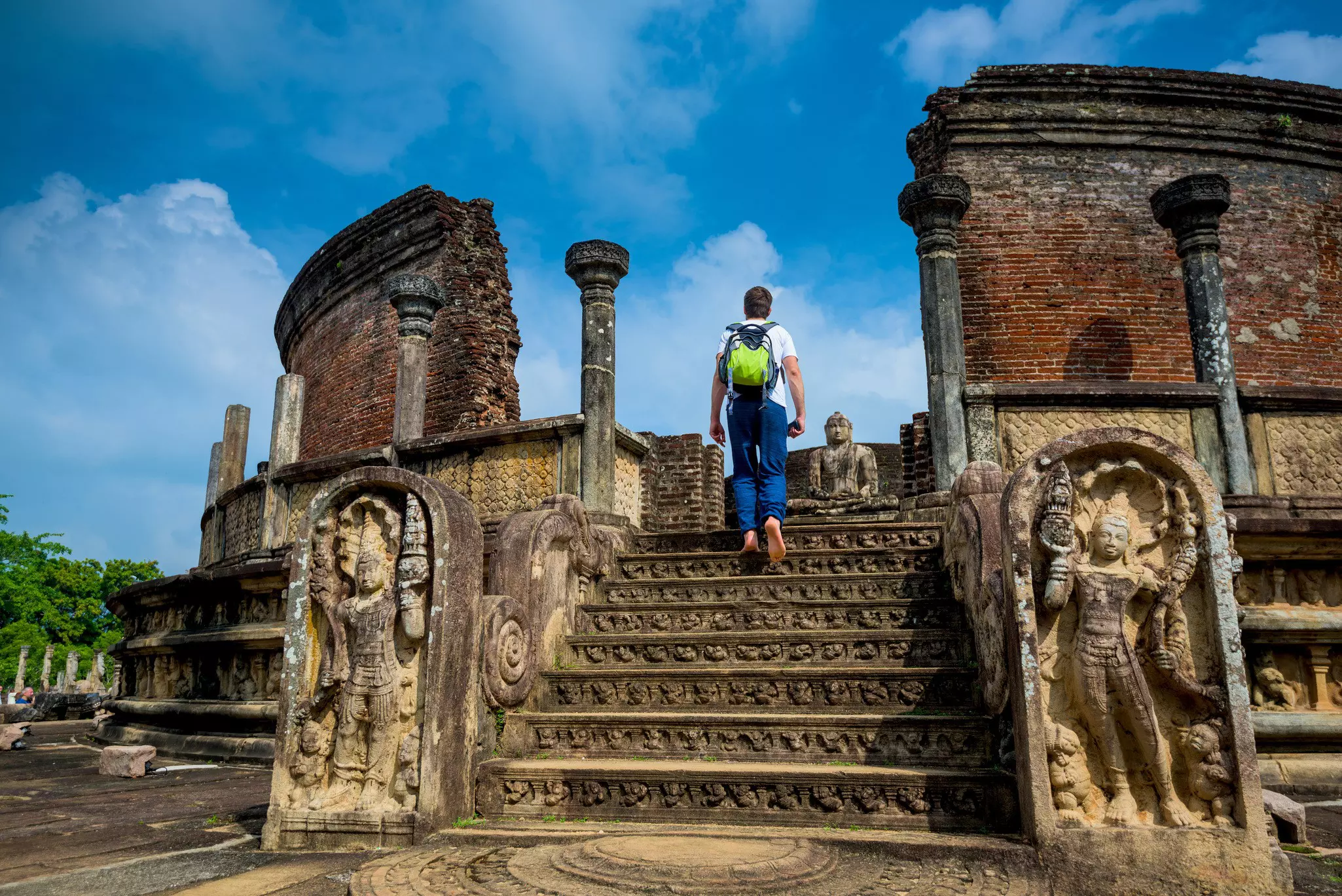 A barefoot visitor walks up steps at an ancient temple in Sri Lanka.