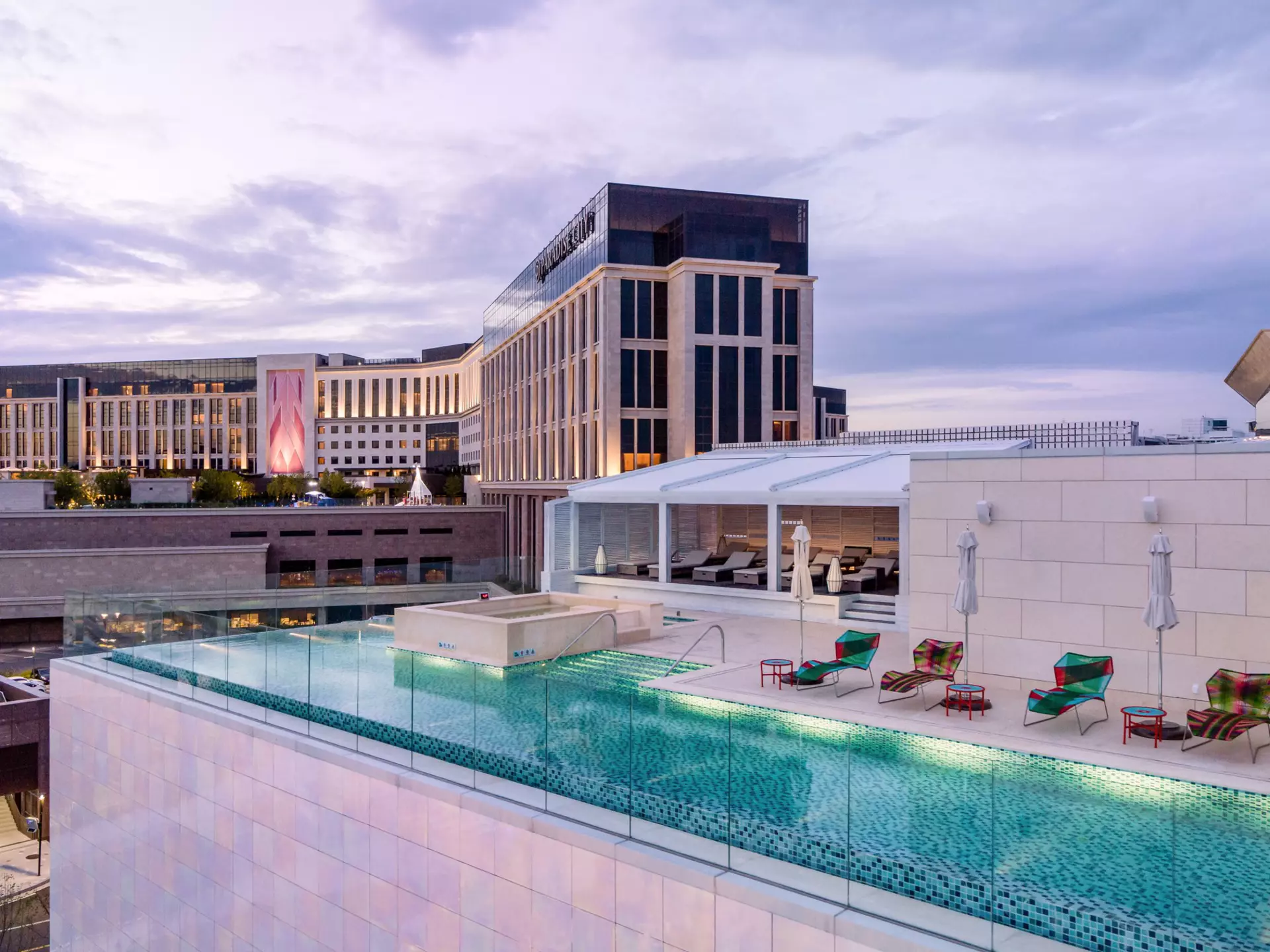 A rooftop infinity pool with sunloungers on a small terrace.