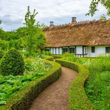 Winding green in Den Fynske Landsby, an open-air museum with traditional Danish architecture in Odense, Denmark.