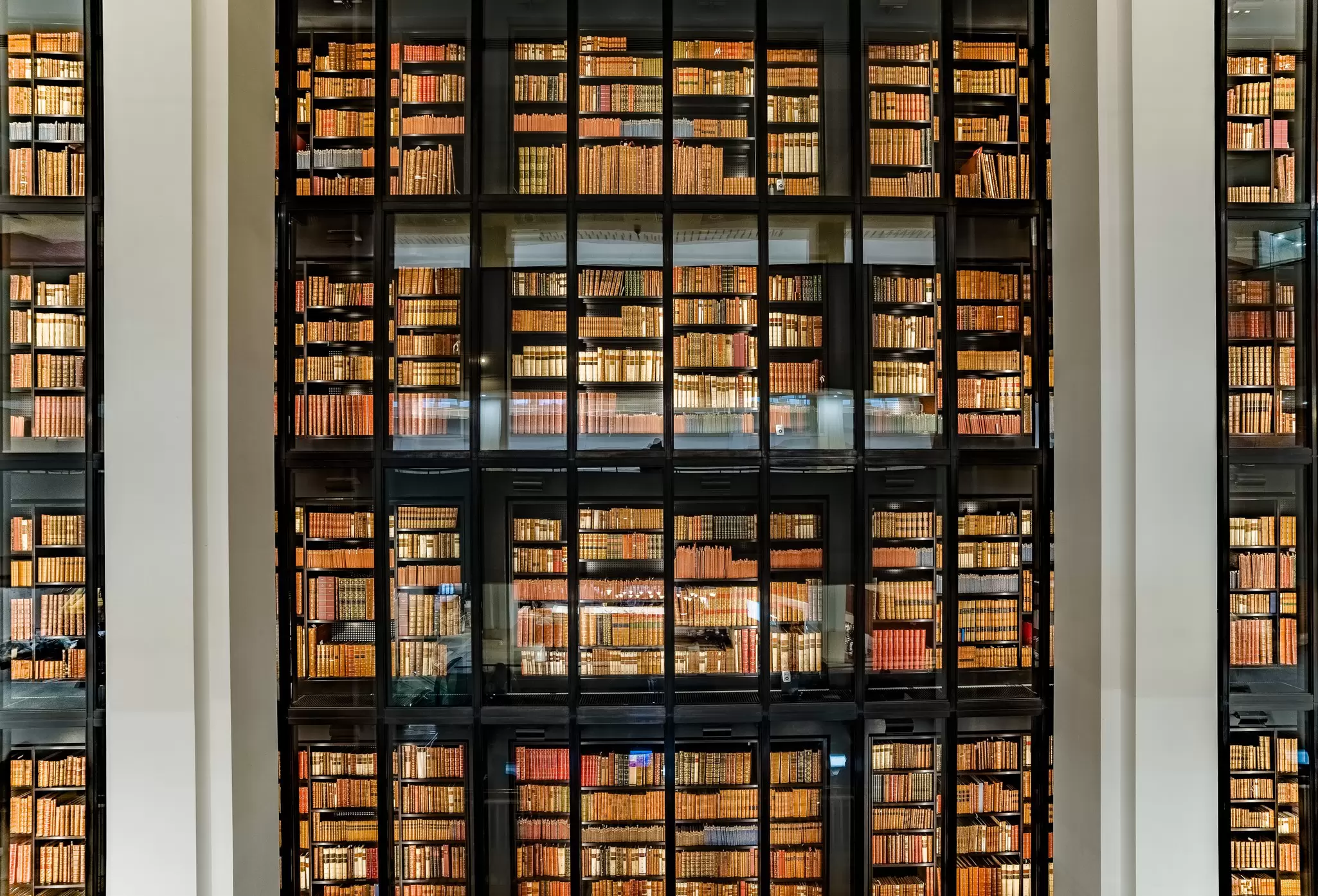 View of a glass-enclosed wall of books at the British Library in London, UK.