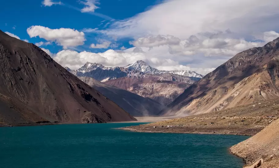 Embalse El Yeso, Cajón del Maipo: blue-green reservoir between bare brown slopes and snowcapped Andean peaks
