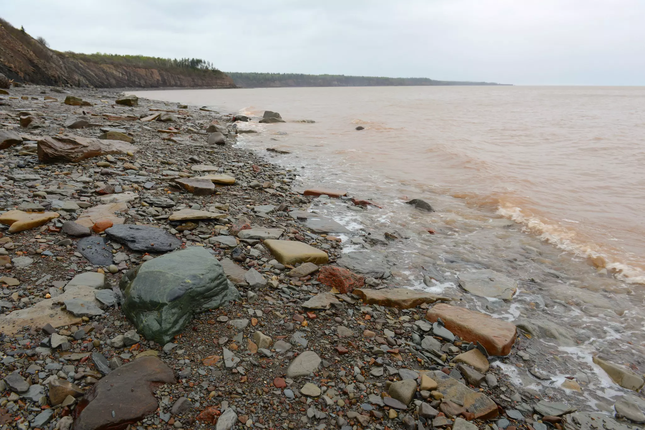 A jagged rocky coastline with waves lapping at the shore