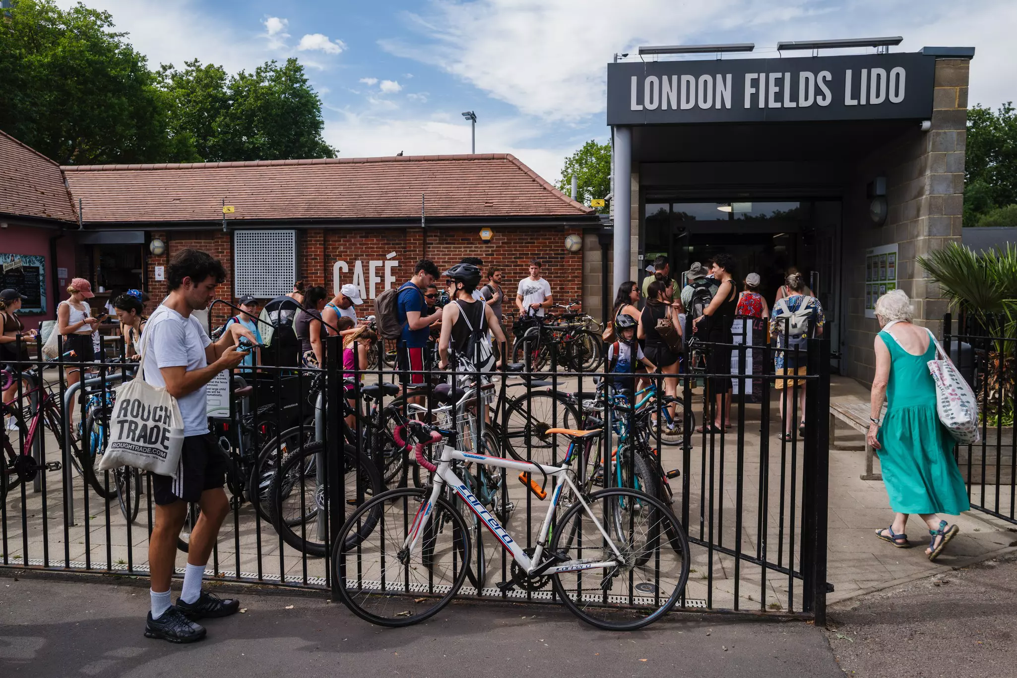 People queue to enter London Fields Lido during a heat wave in London.
