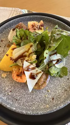 Plated salad served on grey dish. 