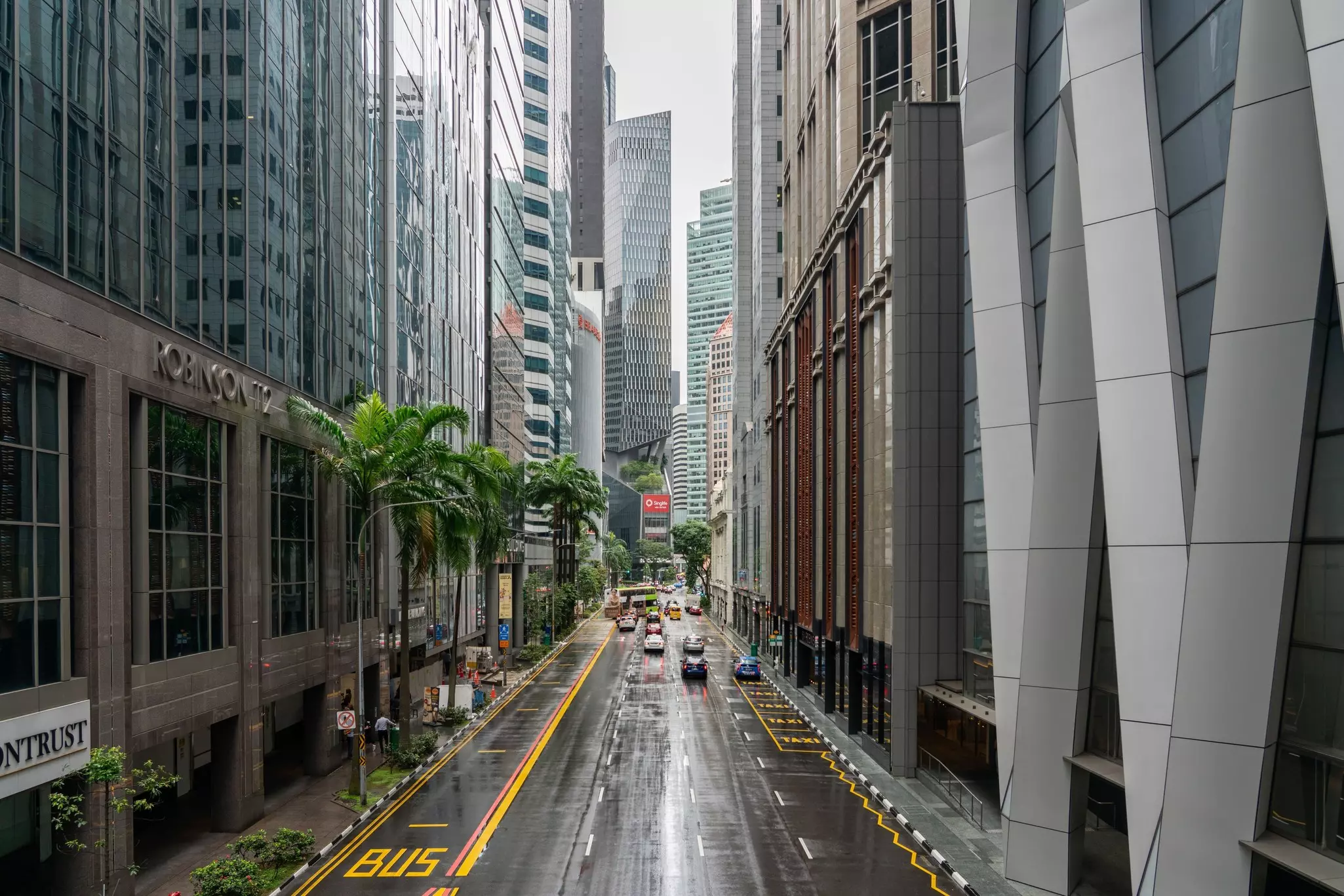 A street lined with tall buildings is pictured in the rain.