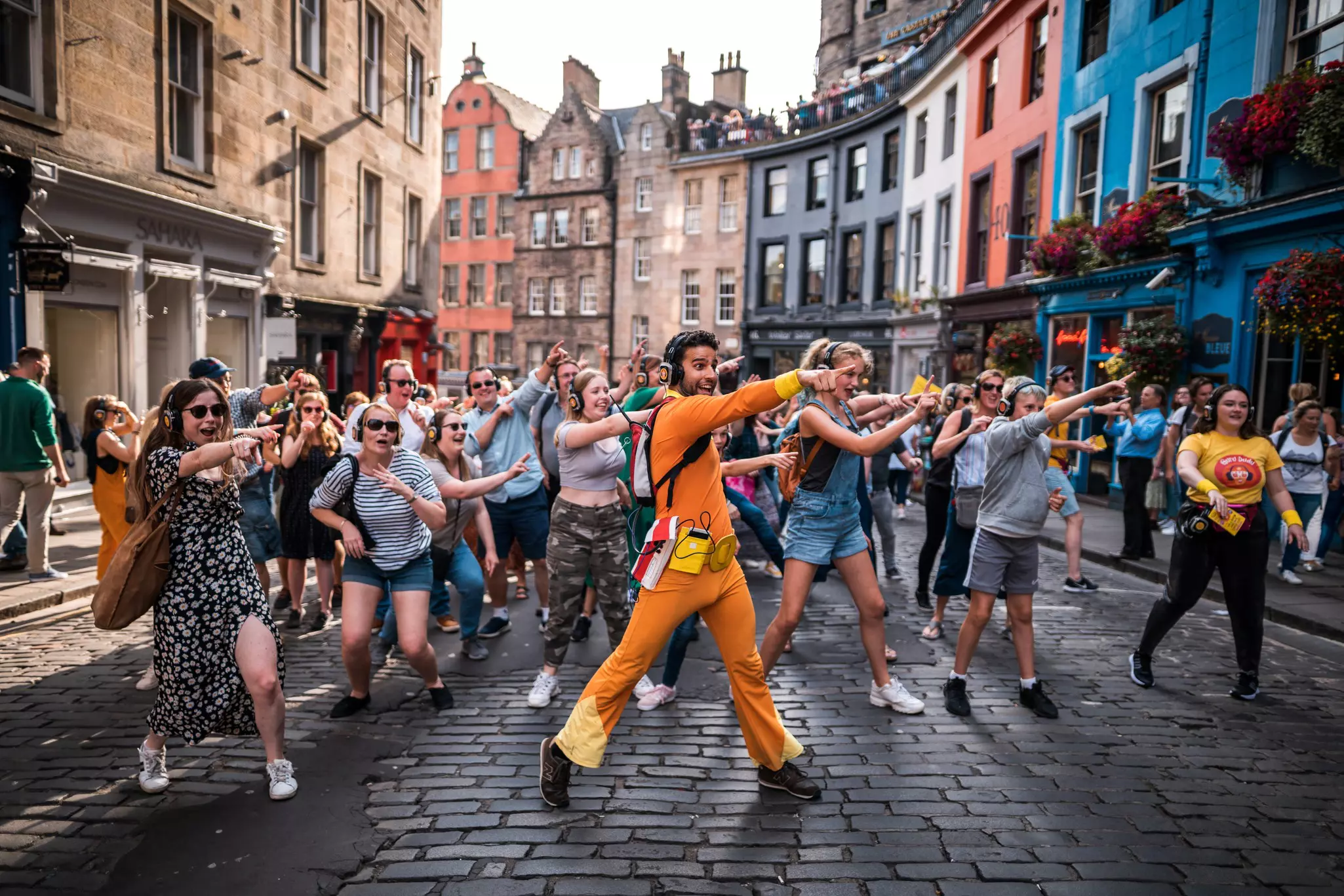 People dance with headphones at a silent disco in the streets of Edinburgh.