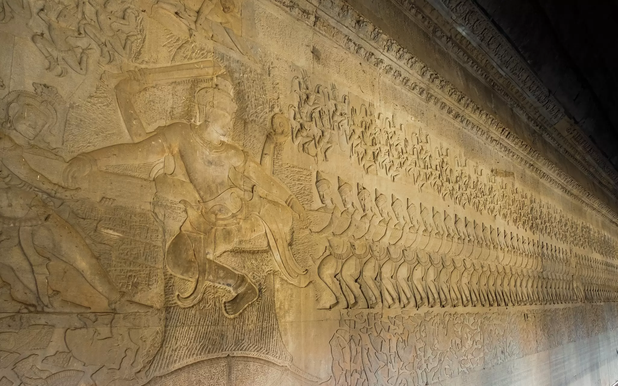 Ancient Khmer bas relief carving showing a row of Devas, angels, pulling on the snake Vasuki. Legend of the churning of the Ocean of Milk, Angkor Wat temple, Cambodia.