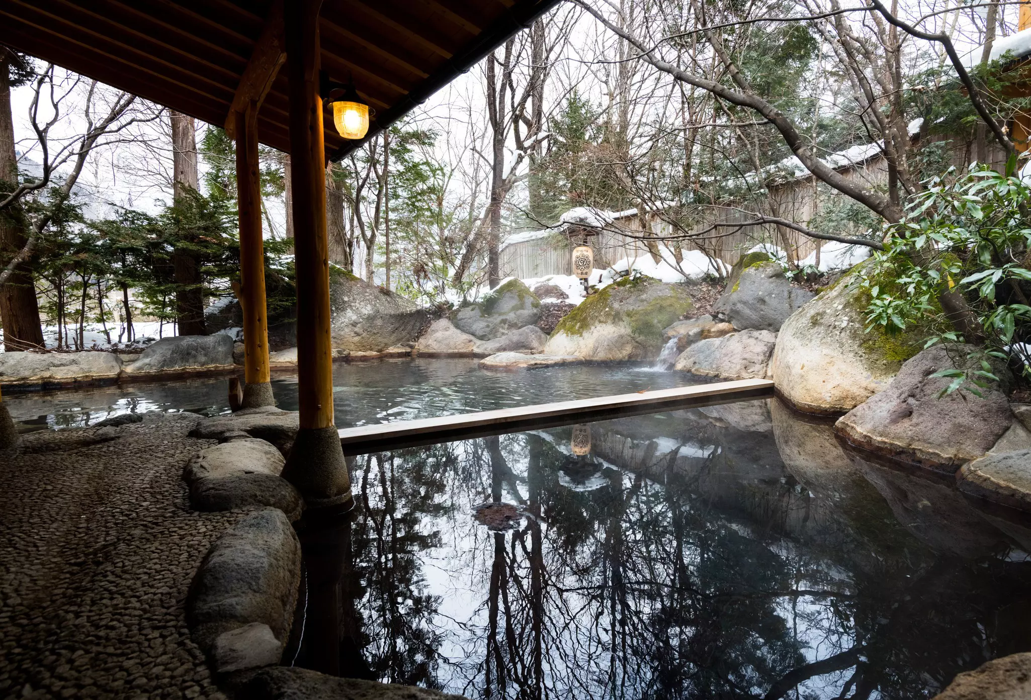 A steaming onsen surrounded by snow in Osaka