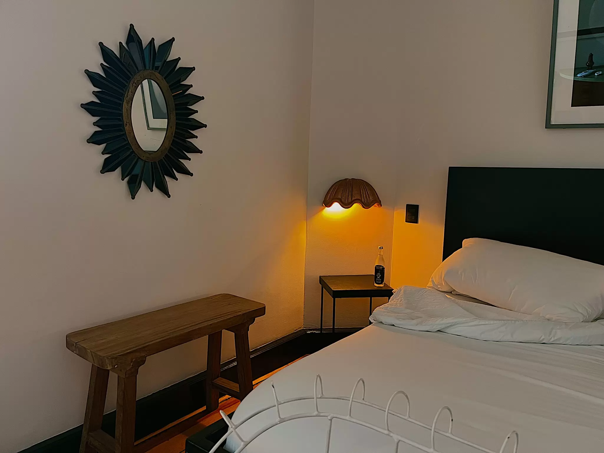 Bed and side table with a muted wall light