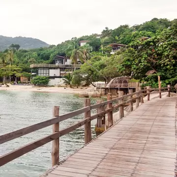 Boardwalk and pier on Haad Leela beach in Koh Pha-Ngan, Thailand. Mountains and hills in background. 