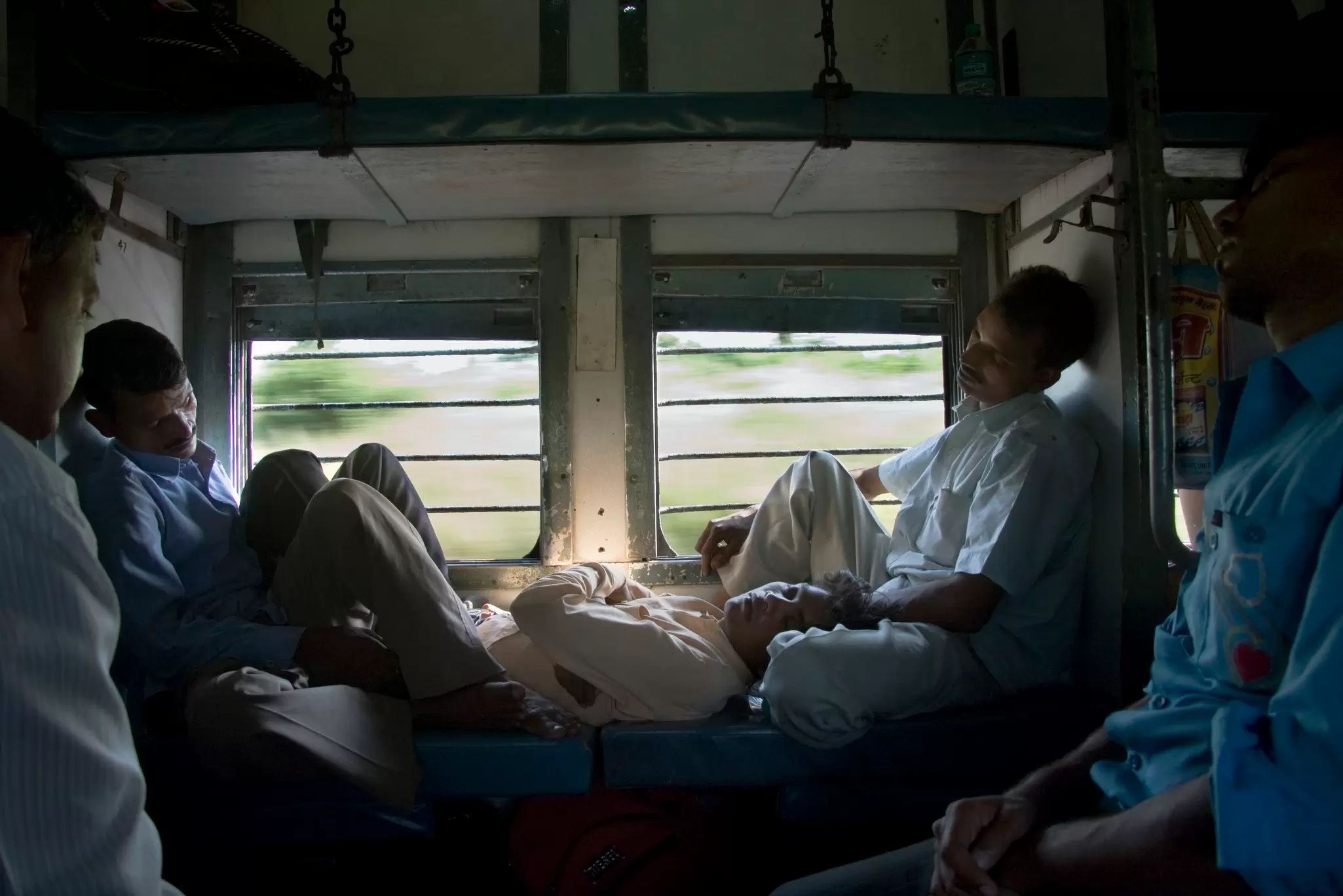 Passengers sleeping in a busy sleeper-class train carriage in Mumbai, India.