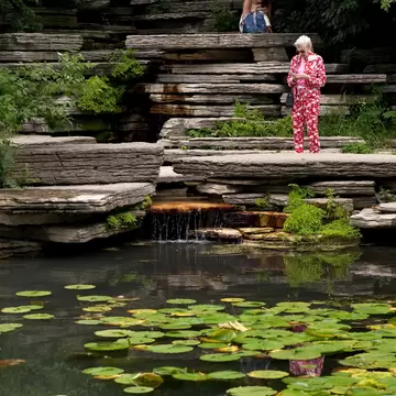 July 29, 2014: Two women check their phones next to the Alfred Caldwell Lily Pool in Lincoln Park Conservatory.