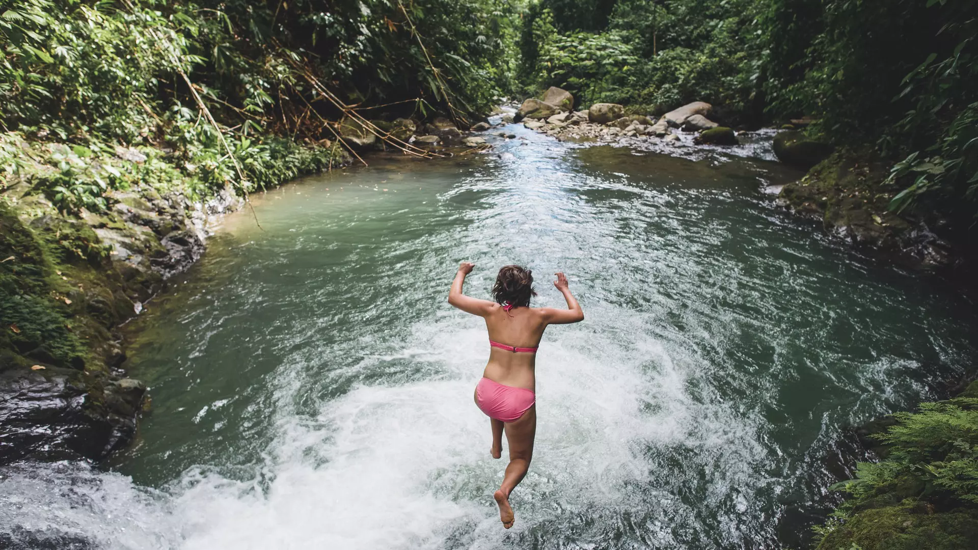 High angle view of carefree woman jumping into lake amidst forest.USA, Missouri, Kansas City