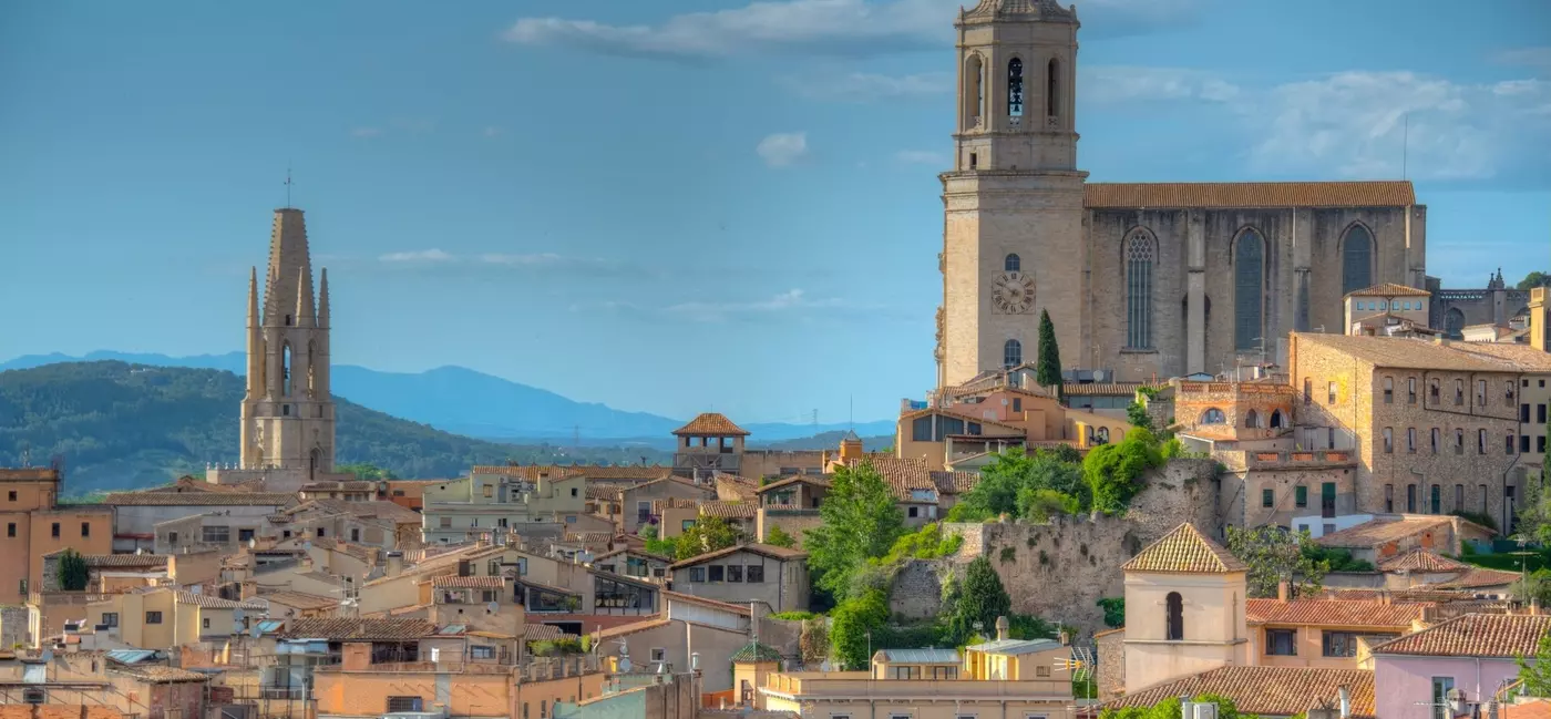 A city with a large central cathedral and buildings with terracotta rooftops.