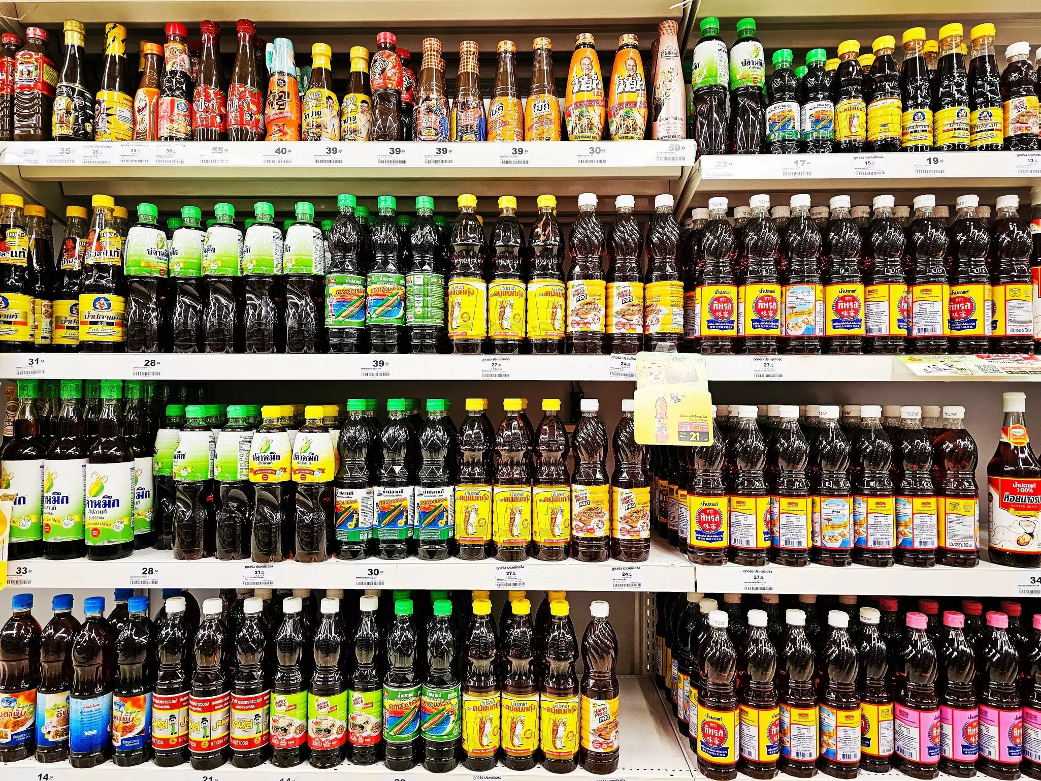 Various brands of Thai fish sauce on market shelves. Window display of fish sauce in supermarket.