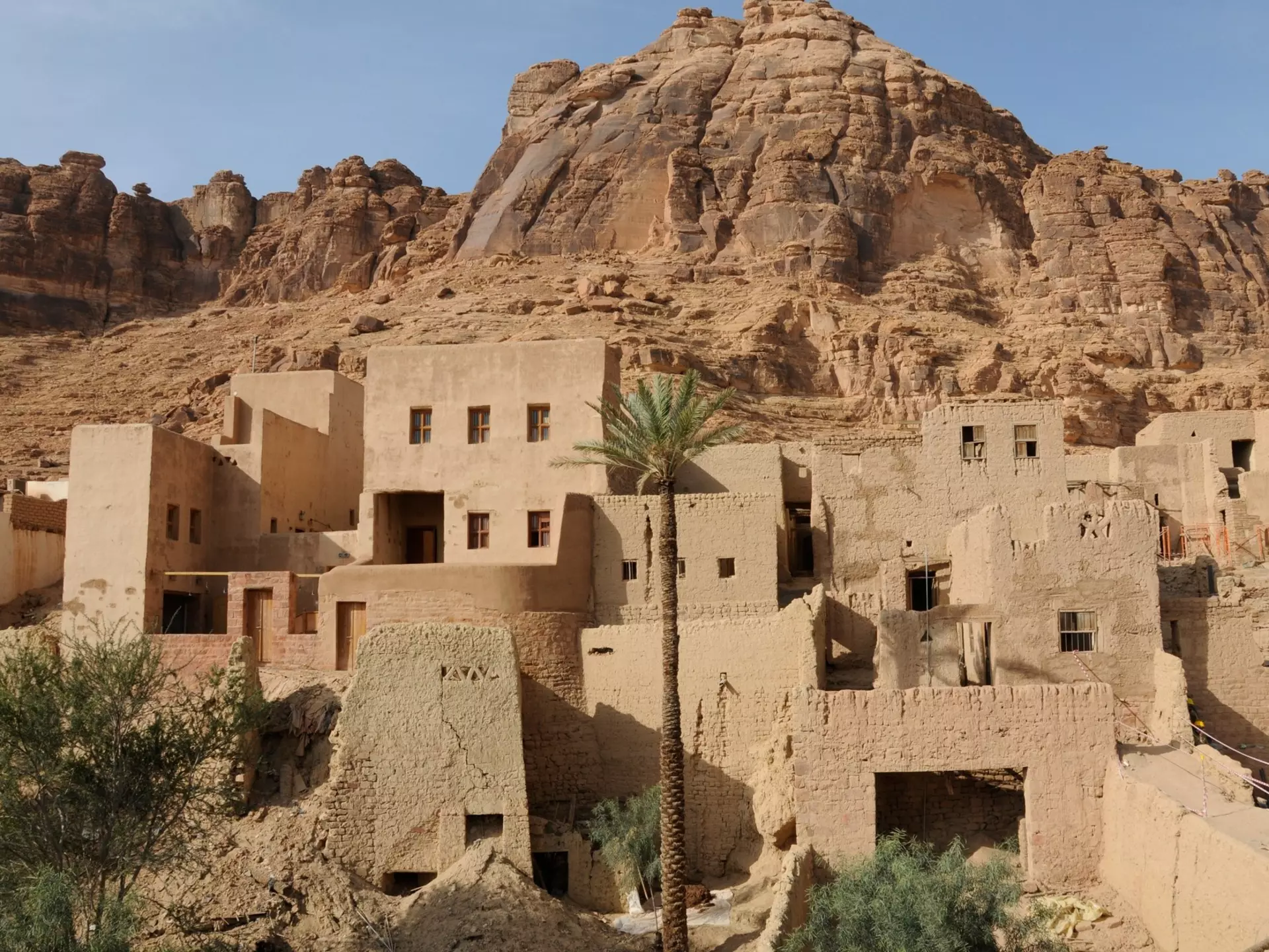 Old sandstone structures at the base of a rock formation. 