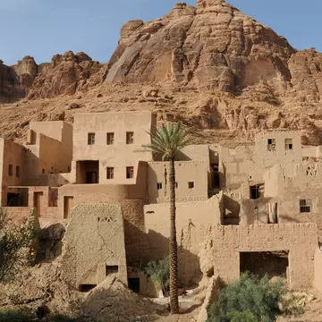 Old sandstone structures at the base of a rock formation. 